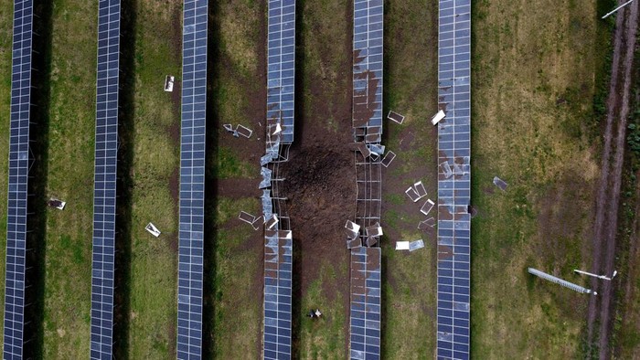 PLTS di Kharkiv Ukraina Rusak Dihantam Serangan Rudal Vladimir Mihailovich, a solar plant manager, walks next to a crater after a shelling hit the station that was producing 2.5 megawatts of power, amid Russia's attack on Ukraine, in the town of Merefa on the outskirts of Kharkiv, Ukraine May 28, 2022. Picture taken with a drone. REUTERS/Ivan Alvarado TPX IMAGES OF THE DAY
