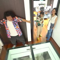 Sebuah tangga besar mengubungkan lantai satu dan dua. Setiba di atas, langsung disambut lantai transparan yang bisa bikin deg-degan orang dengan fobia ketinggian. (Foto: YouTube/Trans7 Official)