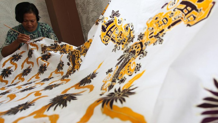 RUMAH KREATIF BATIK PUTAT JAYA Perajin membatik dengan kuas di selembar kain di Rumah Kreatif Batik Putat Jaya, Surabaya, Jawa Timur, Senin (30/5/2022). Tempat untuk pelatihan batik bagi masyarakat tersebut juga memproduksi batik dengan berbagai motif yang dijual ke pasaran dengan kisaran harga Rp125 ribu sampai Rp5 juta per lembar. ANTARA FOTO/Didik Suhartono/aww.