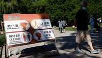 Tanda berisi informasi jarak sosial dan langkah-langkah kesehatan dipasang di Sun Park, Beijing.