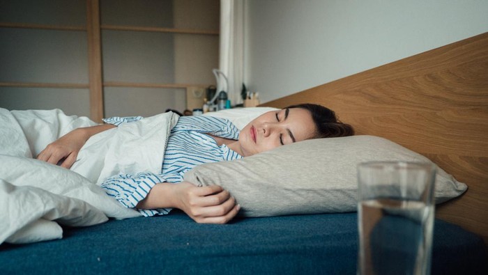 air minum Young asian with high fever coughing and taking a medicine in the bed.