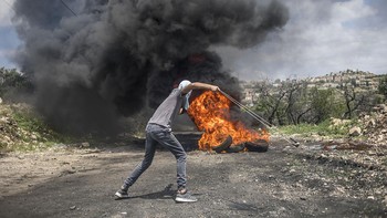 Karya finalis  Bruno Thevenin dari Spanyol. Menampilkan warga Palestina terlihat menggunakan ketapel saat berhadapan denga tentara Israel selama bentrokan di desa Kafr Qaddum Foto: All About Photo Awards