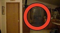 Seorang pria mengabadikan bayangan hitam yang berada di bagian dapur gelap di rumahnya. Bayangan hitam itu terlihat seperti sosok orang yang melayang. Foto: Pool/Site News