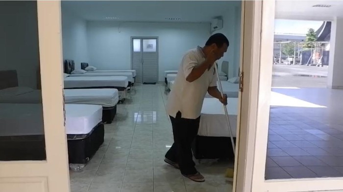 Salah seorang petugas Asrama Haji Padang, sedang membersihkan kamar-kamar yang akan digunakan calon  Jemaah Haji. (Jeka Kampai/detikSumut)