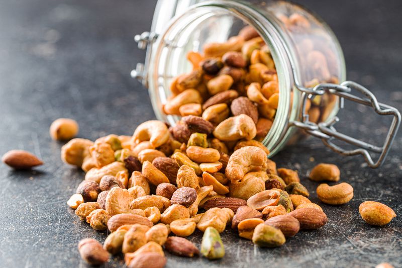 Ilustrasi Kacang Telur Spicy flavoured nuts. Mix of nuts in jar.