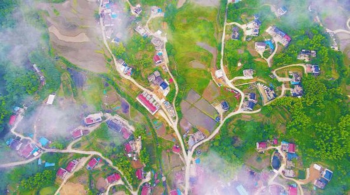 ANQING, CHINA - MAY 31, 2022 - Aerial photo taken on May 31, 2022 shows muchong community in Tiantang Town, Yuexi County, Anqing City, East China's Anhui Province. The highway connecting the village and the castle peak, the stacked terraced fields and the well-arranged residential buildings complement each other. In recent years, Anqing city has strengthened the construction, operation and management of rural roads, carried out quality improvement projects as a whole, and built a reasonable layout and smooth road network. Highways run through the beautiful mountains and rivers, facilitating villagers' travel, boosting industrial development and providing a strong guarantee for people to increase their income and get rich. (Photo credit should read CFOTO/Future Publishing via Getty Images)