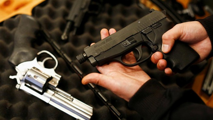 A legal owner poses with his 9mm Sig Sauer P239 after Canadas government introduced legislation to implement a 