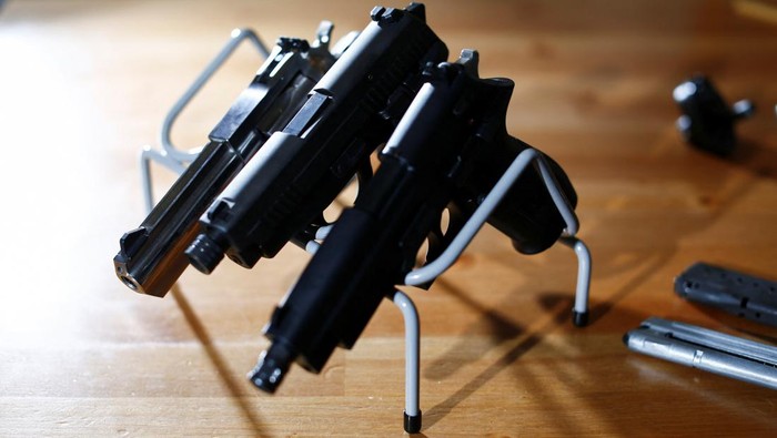 Kekerasan Bersenjata Makin Marak, Kanada Bakal Larang Warganya Punya Pistol A legal owner poses with his 9mm Sig Sauer P239 after Canada's government introduced legislation to implement a