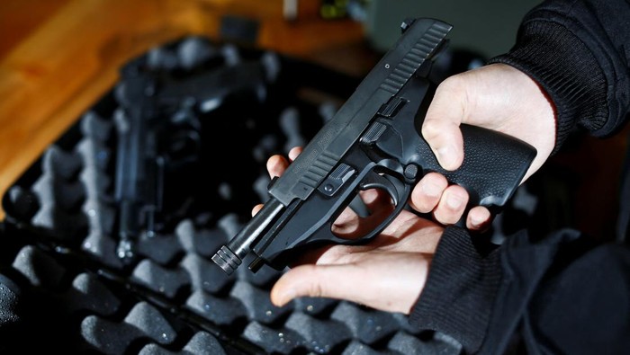 A legal owner poses with his 9mm Sig Sauer P239 after Canadas government introduced legislation to implement a 