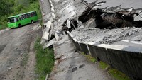 Bus melintasi reruntuhan jembatan di pinggiran Kota Kharkiv.