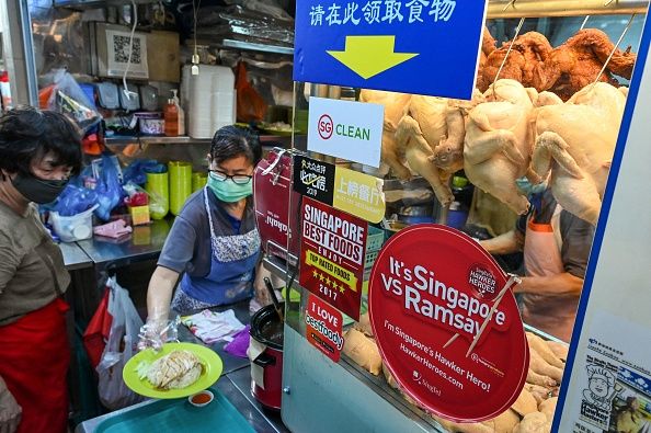Malaysia Bakal Setop Ekspor Ayam, Pedagang di Singapura Panik A vendor prepares a plate of chicken rice at a hawker centre in Singapore on May 31, 2022. - Singapore imports a third of its chicken supply from Malaysia, which will halt the export of 3.6 million chickens a month from June 1 onwards, amid surging prices and supply concerns. (Photo by Roslan RAHMAN / AFP) (Photo by ROSLAN RAHMAN/AFP via Getty Images)