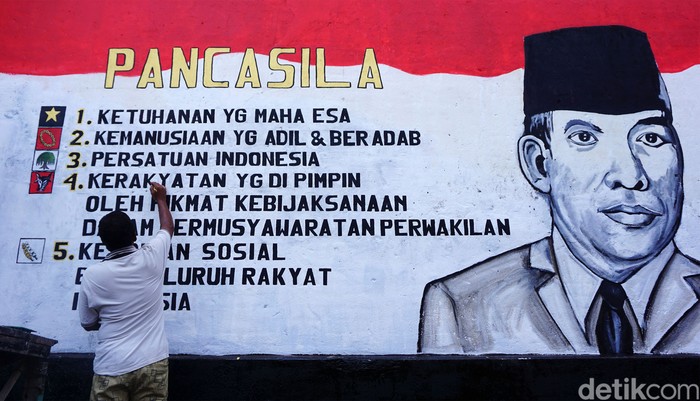 Warga menyelesaikan proses pengecatan mural bertemakan Pancasila dengan media tembok rumah di jalan masuk Dusun Karangwatu, Pucungrejo, Muntilan, Magelang, Jawa Tengah, Selasa (31/5/2022). Pembuatan mural tersebut dalam rangka memperingati hari lahirnya Pancasila pada tanggal 1 Juni.