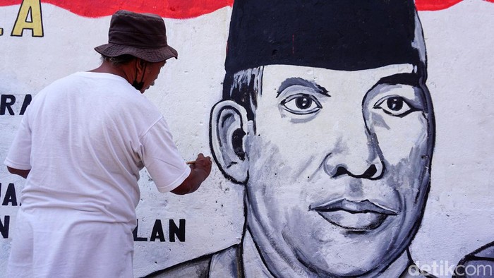 Warga menyelesaikan proses pengecatan mural bertemakan Pancasila dengan media tembok rumah di jalan masuk Dusun Karangwatu, Pucungrejo, Muntilan, Magelang, Jawa Tengah, Selasa (31/5/2022). Pembuatan mural tersebut dalam rangka memperingati hari lahirnya Pancasila pada tanggal 1 Juni.