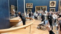 Petugas membersihkan kaca pelindung lukisan Mona Lisa yang kotor karena dilempari kue. Twitter/@Sara_Algaba via REUTERS.