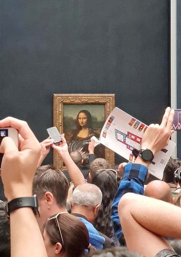 Seperti diketahui, media sosial digegerkan dengan aksi seorang pria yang melempari lukisan Mona Lisa dengan kue ulang tahun. Pria yang memakai wig dan menyamar sebagai lansia. Awalnya, dia duduk di kursi roda namun tiba-tiba berdiri lalu melempari lukisan dengan potongan kue. Untungnya lukisan Mona Lisa dilapisi oleh kaca bingkai pengaman yang tebal sehingga tidak merusak bagian depan. Twitter/@klevisl007/via REUTERS.