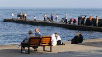 Meski perang antara Rusia dan Ukraina masih berlangsung, tak sedikit warga yang kembali berdatangan ke area tanggul Laut Hitam untuk berenang, memancing, atau sekadar bercengkerama bersama keluarga dan kerabat.