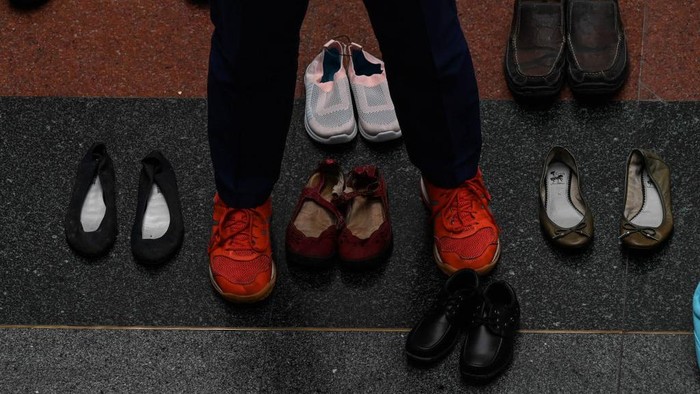 A doctor takes a photo of an art installation with 321 pairs of shoes that signifies the deaths caused by smoking, in observance of the World No Tobacco Day, at the Lung Center of the Philippines in Quezon City, suburban Manila on May 31, 2022. (Photo by JAM STA ROSA / AFP) (Photo by JAM STA ROSA/AFP via Getty Images)