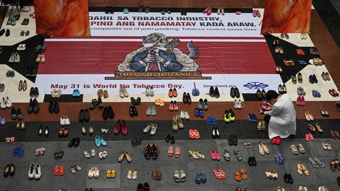Peringatan Hari Tanpa Tembakau Sedunia di Filipina A doctor takes a photo of an art installation with 321 pairs of shoes that signifies the deaths caused by smoking, in observance of the World No Tobacco Day, at the Lung Center of the Philippines in Quezon City, suburban Manila on May 31, 2022. (Photo by JAM STA ROSA / AFP) (Photo by JAM STA ROSA/AFP via Getty Images)