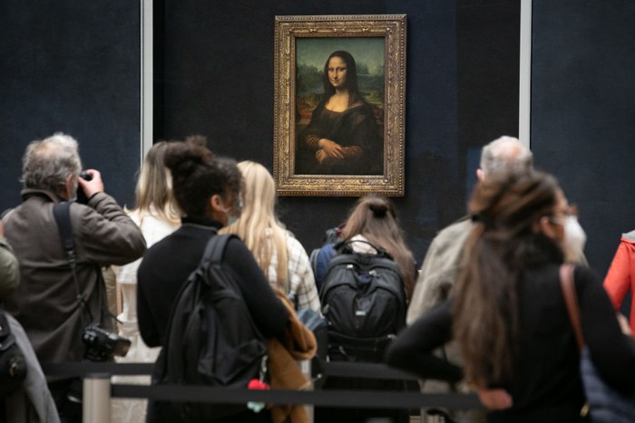 PARIS, FRANCE - MAY 19: Visitors observe the painting La Joconde The Mona Lisa by Italian artist Leonardo Da Vinci on display in a gallery at Louvre on May 19, 2021 in Paris, France. The country is taking steps to ease the lockdown measures that President Emmanuel Macron announced on April 29, allowing all the museums and non-essential shops and cultural venues to open and rolling back the curfew to 9pm. The cafe and restaurant terraces can also open to 50% capacity. France is reporting a seven-day average of around 14,000 new Covid-19 cases. (Photo by Marc Piasecki/Getty Images)