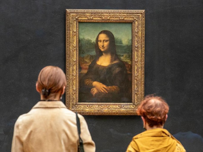 PARIS, FRANCE - MAY 19: Visitors observe the painting La Joconde The Mona Lisa by Italian artist Leonardo Da Vinci on display in a gallery at Louvre on May 19, 2021 in Paris, France. The country is taking steps to ease the lockdown measures that President Emmanuel Macron announced on April 29, allowing all the museums and non-essential shops and cultural venues to open and rolling back the curfew to 9pm. The cafe and restaurant terraces can also open to 50% capacity. France is reporting a seven-day average of around 14,000 new Covid-19 cases. (Photo by Marc Piasecki/Getty Images)
