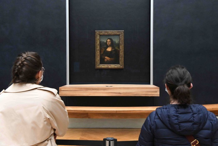 PARIS, FRANCE - MAY 19: Visitors observe the painting 'La Joconde' The Mona Lisa by Italian artist Leonardo Da Vinci on display in a gallery at Louvre on May 19, 2021 in Paris, France. The country is taking steps to ease the lockdown measures that President Emmanuel Macron announced on April 29, allowing all the museums and non-essential shops and cultural venues to open and rolling back the curfew to 9pm. The cafe and restaurant terraces can also open to 50% capacity. France is reporting a seven-day average of around 14,000 new Covid-19 cases. (Photo by Marc Piasecki/Getty Images)