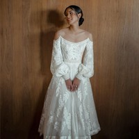 Maudy Ayunda tampil cantik dan anggun berbalut gaun pengantin karya desainer Hian Tjen. Gaun berbahan lace ini tampak unik dengan ilusi off-the-shoulder dan lengan bervolume. Foto: Instagram/@maudyayunda @iluminen