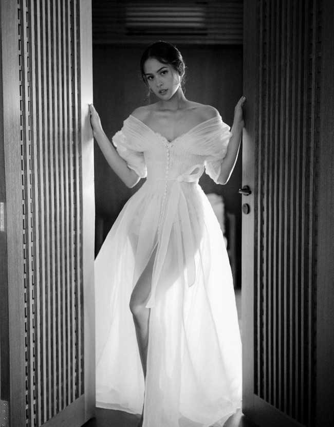 Sebelum tampil di acara resepsi, Maudy Ayunda juga melakukan sesi foto mengenakan bridal robe, masih dari koleksi Hian Tjen. Busana bergaya era Victorian ini menonjolkan aura seksi yang elegan dengan material transparan, potongan korset serta high-slit. Foto: Instagram/@maudyayunda @iluminen