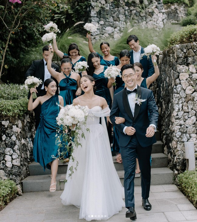Tak hanya satu, Hian Tjen merancang dua gaun pengantin untuk dipakai Maudy Ayunda. Kali ini ia mengenakan gaun berpotongan ballgown dengan aksen tulle pada lengan. Foto: Instagram/@maudyayunda @iluminen