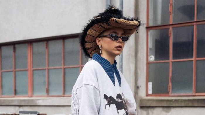 COPENHAGEN, DENMARK - FEBRUARY 03: Emma Fridsell wearing blue jeans, jumper with horses and brawn cowboy hat outside Jade Cropper in Copenhagen fashion week Autumn/Winter 2022 on February 03, 2022 in Copenhagen, Denmark. (Photo by Raimonda Kulikauskiene/Getty Images)