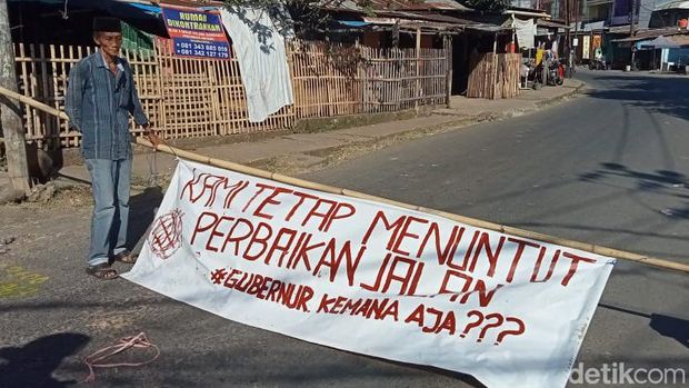 Warga memblokade jalan dan memasang spanduk protes karena kerusakan Jalan Antang Raya tak kunjung ditangani