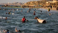 Mereka memanfaatkan wisata air di pantai untuk sekedar mendinginkan tubuh.