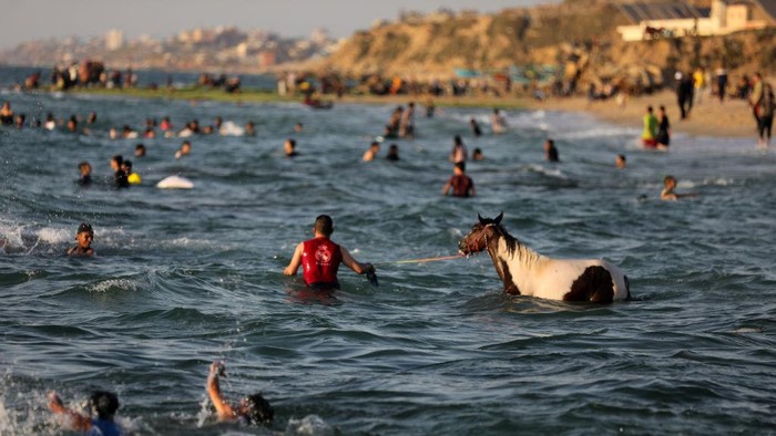1241015941 Palestinians enjoy the beach of the sea in Deir al-Balah in the center of the Gaza Strip, during a hot day, on May 31, 2022. (Photo by Majdi Fathi/NurPhoto via Getty Images)