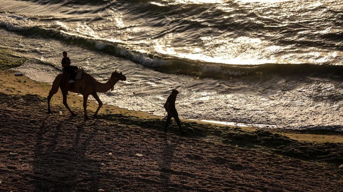 Palestinians enjoy the beach of the sea in Deir al-Balah in the center of the Gaza Strip, during a hot day, on May 31, 2022. (Photo by Majdi Fathi/NurPhoto via Getty Images)