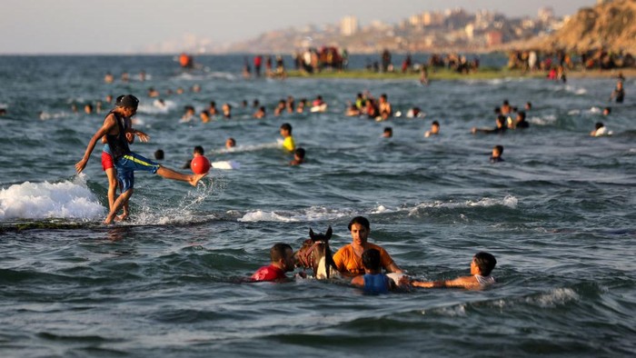 Palestinians enjoy the beach of the sea in Deir al-Balah in the center of the Gaza Strip, during a hot day, on May 31, 2022. (Photo by Majdi Fathi/NurPhoto via Getty Images)
