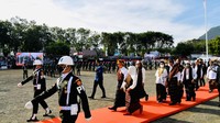Jokowi mengenakan pakaian adat Ende dengan perpaduan warna merah, putih, dan hitam. 