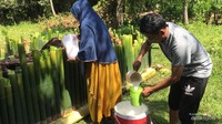 Menyusun lemang di sekeliling kayu bakar, mengisinya dengan santan kental kemudian ditutup dengan bilah bambu tipis.