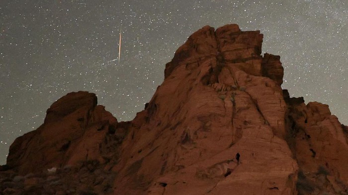 VALLEY OF FIRE STATE PARK, NEVADA - MAY 30: A meteor streaks above sandstone formations as the Earth passes through the debris trails of a broken comet called 73P/Schwassmann-Wachmann, or SW3, producing a never-before-seen meteor shower called the tau Herculids on May 30, 2022 in the Valley of Fire State Park, Nevada. SW3, which orbits the sun every 5.4 years, crumbled in 1995, resulting in large fragments spewing material that the Earth is passing through for the first time. (Photo by Ethan Miller/Getty Images)