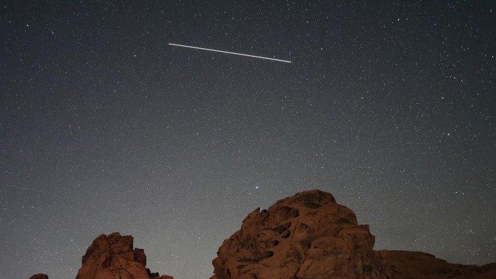 VALLEY OF FIRE STATE PARK, NEVADA - MAY 30: A meteor streaks above sandstone formations as the Earth passes through the debris trails of a broken comet called 73P/Schwassmann-Wachmann, or SW3, producing a never-before-seen meteor shower called the tau Herculids on May 30, 2022 in the Valley of Fire State Park, Nevada. SW3, which orbits the sun every 5.4 years, crumbled in 1995, resulting in large fragments spewing material that the Earth is passing through for the first time. (Photo by Ethan Miller/Getty Images)