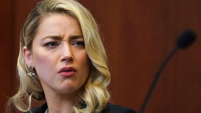 Actor Amber Heard reacts as a pre-recorded deposition testimony of Christian Carino is played during her ex-husband Johnny Depps defamation trial against her, at the Fairfax County Circuit Courthouse in Fairfax, Virginia, April 27, 2022. - US actor Johnny Depp sued his ex-wife Amber Heard for libel in Fairfax County Circuit Court after she wrote an op-ed piece in The Washington Post in 2018 referring to herself as a public figure representing domestic abuse. (Photo by JONATHAN ERNST / POOL / AFP) (Photo by JONATHAN ERNST/POOL/AFP via Getty Images)