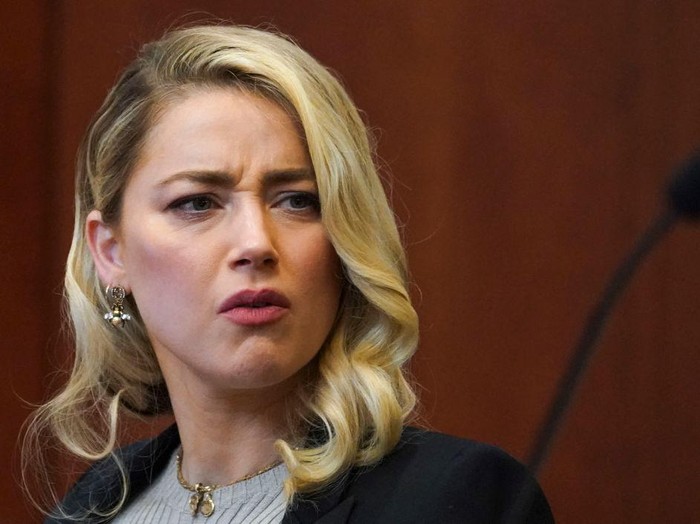 Actor Amber Heard reacts as a pre-recorded deposition testimony of Christian Carino is played during her ex-husband Johnny Depps defamation trial against her, at the Fairfax County Circuit Courthouse in Fairfax, Virginia, April 27, 2022. - US actor Johnny Depp sued his ex-wife Amber Heard for libel in Fairfax County Circuit Court after she wrote an op-ed piece in The Washington Post in 2018 referring to herself as a 