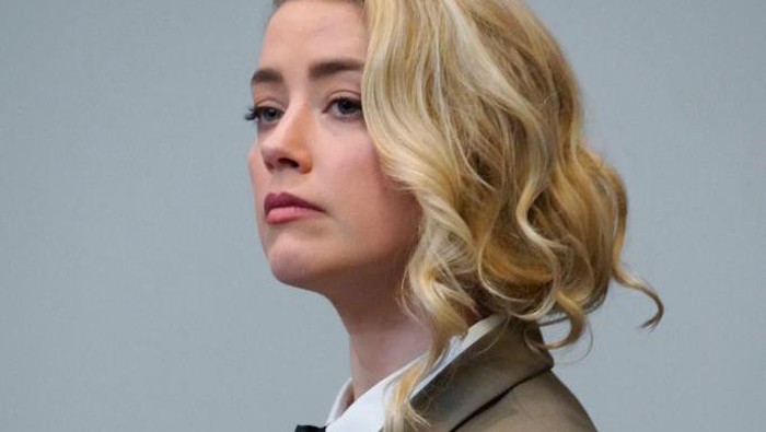 Actor Amber Heard reacts as a pre-recorded deposition testimony of Christian Carino is played during her ex-husband Johnny Depps defamation trial against her, at the Fairfax County Circuit Courthouse in Fairfax, Virginia, April 27, 2022. - US actor Johnny Depp sued his ex-wife Amber Heard for libel in Fairfax County Circuit Court after she wrote an op-ed piece in The Washington Post in 2018 referring to herself as a public figure representing domestic abuse. (Photo by JONATHAN ERNST / POOL / AFP) (Photo by JONATHAN ERNST/POOL/AFP via Getty Images)