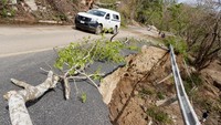 Sebuah mobil melewati jalan yang rusak akibat Badai Agatha, di Zipolite, negara bagian Oaxaca, Meksiko.