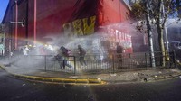 Tampak sebuah kendaraan water cannon digunakan untuk membubarkan massa saat pengunjuk rasa terlihat menyerang kendaraan polisi dengan tongkat dan bom molotov.  