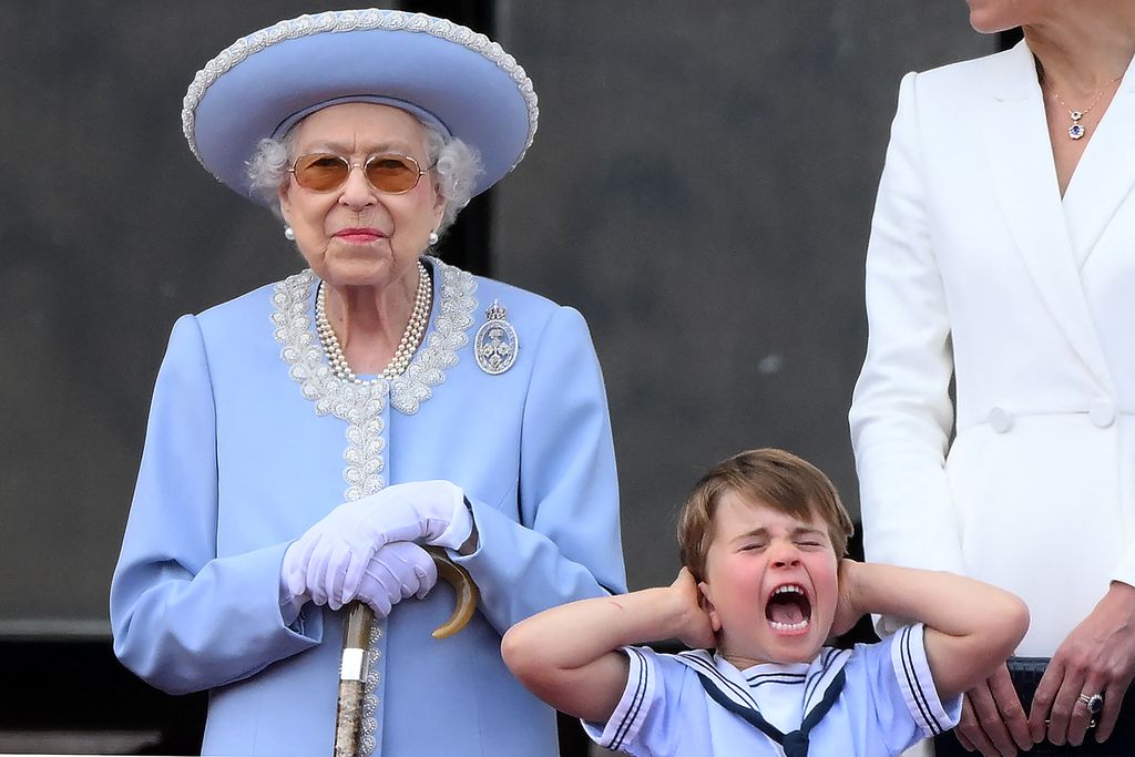 TOPSHOT - Britain's Prince Louis of Cambridge (R) holds his ears as he stands next to Britain's Queen Elizabeth II to watch a special flypast from Buckingham Palace balcony following the Queen's Birthday Parade, the Trooping the Colour, as part of Queen Elizabeth II's platinum jubilee celebrations, in London on June 2, 2022. - Huge crowds converged on central London in bright sunshine on Thursday for the start of four days of public events to mark Queen Elizabeth II's historic Platinum Jubilee, in what could be the last major public event of her long reign. (Photo by Daniel LEAL / AFP) (Photo by DANIEL LEAL/AFP via Getty Images)