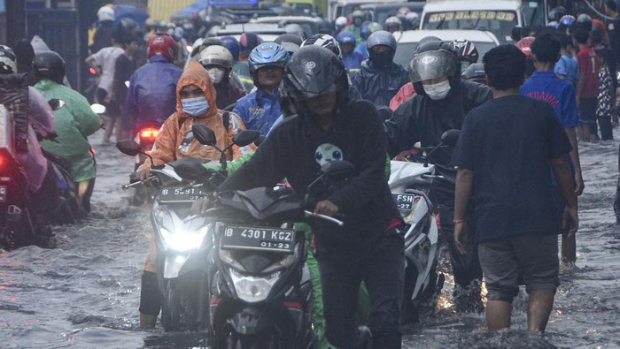 GENANGAN AIR DI JALAN BEKASI Sejumlah sepeda motor mendorong kendaraanya yang mogok saat melintasi genangan air di Jalan Kaliabang, Bekasi, Jawa Barat, Kamis (2/6/2022). Genangan air usai hujan dengan ketinggian 20 cm hingga 40 cm terjadi karena kualitas drainase yang buruk dan mengakibatkan kendaraan sepeda motor pengguna jalan mogok. ANTARA FOTO. Fakhri Hermansyah/hp.