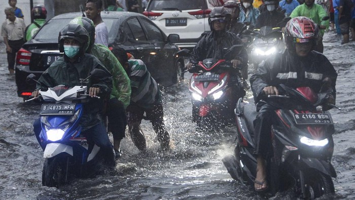 GENANGAN AIR DI JALAN BEKASI Sejumlah sepeda motor mendorong kendaraanya yang mogok saat melintasi genangan air di Jalan Kaliabang, Bekasi, Jawa Barat, Kamis (2/6/2022). Genangan air usai hujan dengan ketinggian 20 cm hingga 40 cm terjadi karena kualitas drainase yang buruk dan mengakibatkan kendaraan sepeda motor pengguna jalan mogok. ANTARA FOTO. Fakhri Hermansyah/hp.
