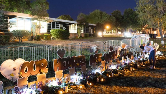 Lilin, Bunga dan Doa untuk Korban Penembakan di SD Texas A man kneels in front of a mound of flowers at a memorial at Robb Elementary School in Uvalde, Texas, Wednesday, June 1, 2022, to pay his respects to the victims killed in last week's school shooting. (AP Photo/Jae C. Hong)