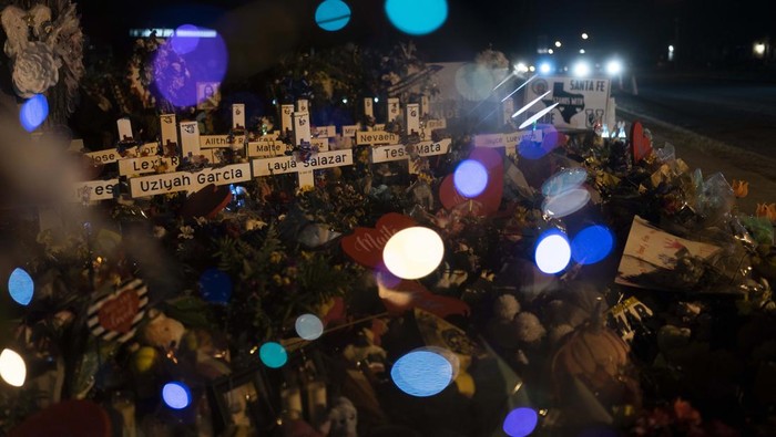Lilin, Bunga dan Doa untuk Korban Penembakan di SD Texas A man kneels in front of a mound of flowers at a memorial at Robb Elementary School in Uvalde, Texas, Wednesday, June 1, 2022, to pay his respects to the victims killed in last week's school shooting. (AP Photo/Jae C. Hong)