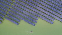 Perahu motor melintas di samping panel surya di Pembangkit Listrik Tenaga Surya (PLTS) Wenling, Zhejiang, China, (30/5/2022). PLTS ini berada di sebelah selatan Ibu Kota Beijing, sekitar 2,5 jam perjalanan menggunakan pesawat udara.