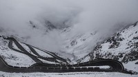 Di balik kelokannya yang tajam, Stelvio Pass menampilkan pemandangan berupa pegunungan yang terbentang.   